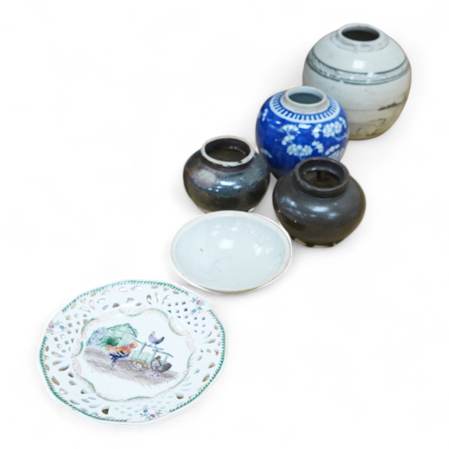 A collection of Chinese pottery jars and a decorated plate, tallest jar 18cm high